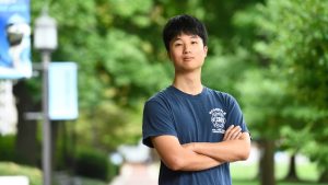 Jooyoung Ryu poses with his arms crossed on the Homewood campus.